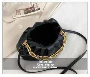 Detail of internal structure of black pleated cloud bag with golden chain and zipper