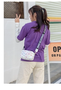 Photo de mode en extérieur du sac à bandoulière blanc géométrique avec sangle logotypée