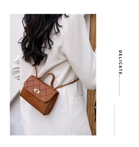 Rear view of model wearing a brown quilted mini crossbody bag with gold twist lock