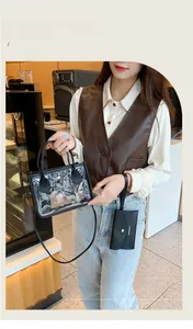 Macro view of clear PVC tote bag with black leather trim and matching small inner pouch