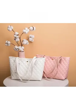 Dettaglio di borse tote trapuntate bianche e rosa con chiusure dorate e manici in pelle
