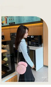 Détail d'un sac rond rose matelassé avec poignée en fourrure et chaîne dorée