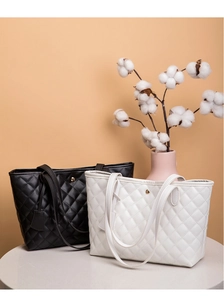 Dettaglio di borse tote in pelle PU trapuntata bianca e nera con fibbie in metallo dorato