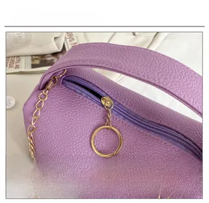 Close-up of purple lychee texture bag featuring smooth gold zipper and chain strap detail