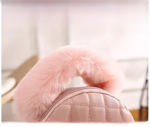 Détail de la poignée en peluche rose et de la texture matelassée du mini sac