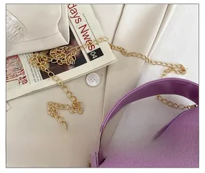 Detail showing purple lychee grain leather texture and elegant golden metal chain strap
