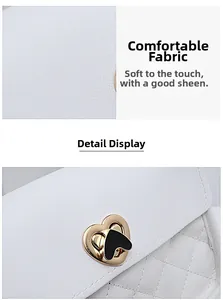 Detail of white quilted crossbody bag with heart-shaped gold clasp and leather texture