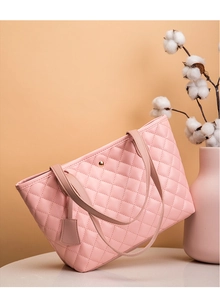 Dettaglio della borsa shopper rosa trapuntata con vaso di fiori per una texture elegante