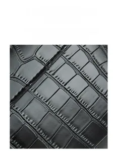 Detailed macro view of black crocodile pattern leather with high gloss texture for mini bags