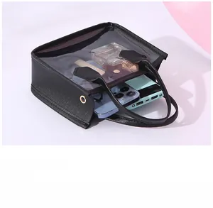 Close-up of black mesh tote bag with leather trim showing interior storage space