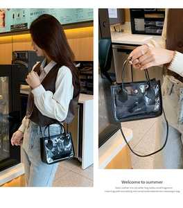 Detailed view of clear PVC tote bag with black inner pouch and golden metal buckle clasp