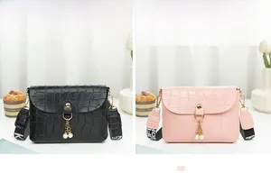 Detail of crocodile pattern small square bags in black and pink with pearl fringe
