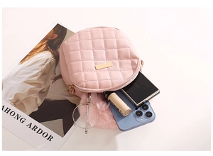 Détail du sac à main matelassé rose avec plaque en métal doré et accessoires stylés