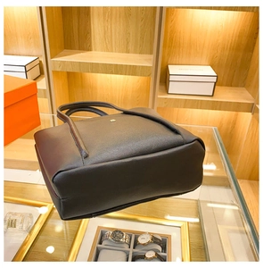 Detail of black pebbled leather tote bag with elegant gold hardware and spacious interior