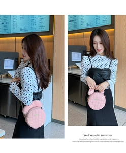 Détail du sac rond rose matelassé avec poignée en peluche et bandoulière dorée