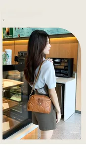 Close-up of brown quilted leather shoulder bag with metallic clasp in a cafe setting