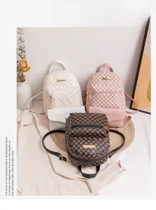 Three mini double-layer backpacks in monogram and colorful styles on a beige blazer