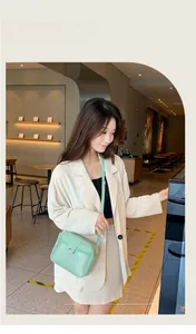 Détail du petit sac bandoulière vert menthe avec lettrage 'FASHION' et rabat magnétique