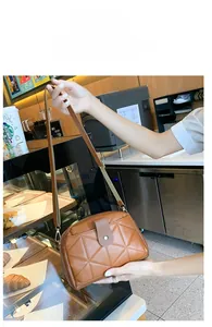 Brown quilted crossbody bag with adjustable strap shown in a lifestyle cafe setting