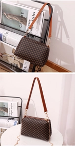 Close-up of vintage brown monogram pillow bag with adjustable leather strap and gold chain