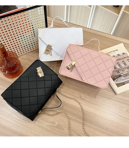 Detailed view of quilted faux leather handbags in white, pink and black with gold hardware