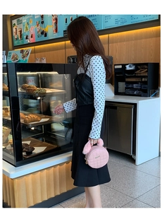 Sac à main rond matelassé rose avec poignée en peluche dans un café chic