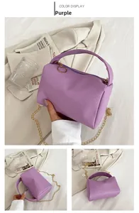 Detail of purple litchi texture pillow bag with gold chain strap and metal handles