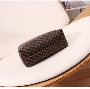Close-up of geometric pattern on a stylish leather handbag placed on a white chair