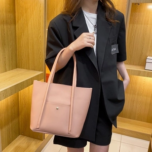 Pink large capacity tote bag with metal buckle pocket, carried by model in a black blazer