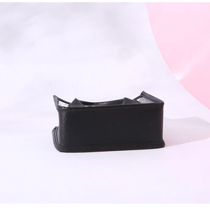 Close-up of black lychee grain faux leather texture and reinforced stitching on the bag