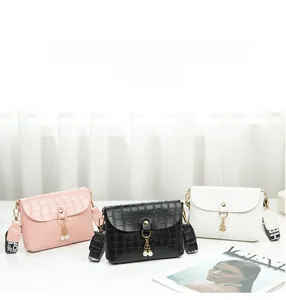 Detailed view of crocodile pattern crossbody bags with tassel and lettered straps