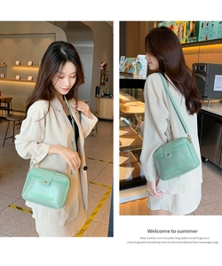 Détail d'un sac bandoulière vert menthe avec lettrage FASHION porté par un mannequin