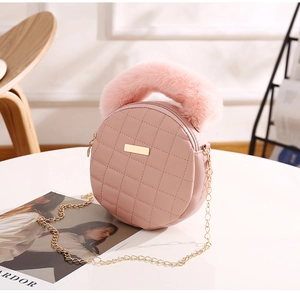 Détail du sac rond rose matelassé avec poignée en peluche et chaîne dorée chic