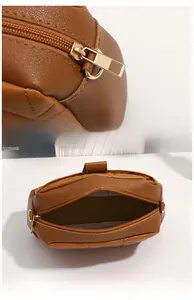 Detail of golden metal zipper and spacious interior of the brown quilted small bag