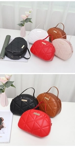 Detail of quilted cosmetic handbag with gold zipper and handle in five vibrant colors