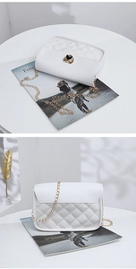 Detail of white quilted chain bag featuring a gold heart lock and embroidery