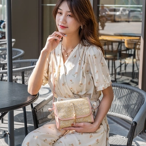 Women's woven straw crossbody bag with pink leather trim and elegant gold metal bar