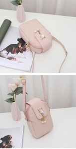 Détail du mini sac de téléphone rose matelassé avec pompon chat perlé et zip doré