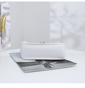 Close-up of smooth white leather texture and gold heart lock on the bag bottom
