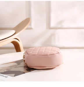 Détail du petit sac rond rose matelassé avec texture cuir de qualité et bandoulière chaîne