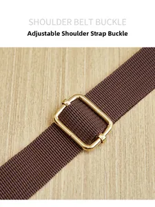 Close-up of golden adjustable metal buckle on dark brown nylon shoulder strap