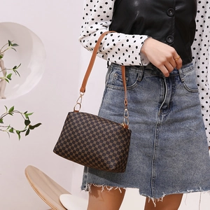 Vintage brown monogram shoulder bag with gold chain strap shown on model in studio