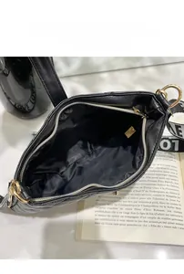 Vista dall'alto di borsa nera trapuntata con interno capiente e cerniere dorate