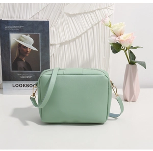 Détail du sac bandoulière vert menthe en cuir grainé avec finitions dorées