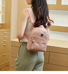Detail of pink monogram mini backpack with gold hardware and adjustable straps on model