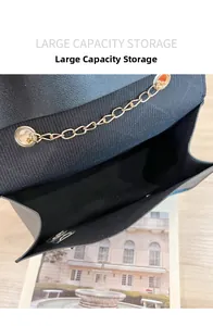 Detail of black leather handbag featuring large capacity storage and gold chain accent