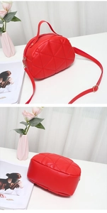 Close-up of red quilted PU leather handbag featuring diamond stitching and adjustable strap