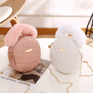 Chic pink and white round quilted crossbody bag with soft faux fur handle and gold chain