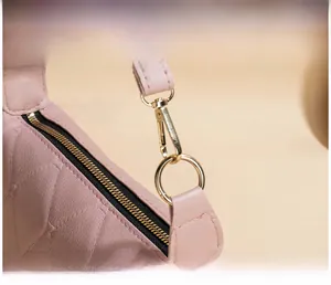 Makrodetail der rosa gesteppten Lederhandtasche mit hochglanzpolierten Goldbeschlägen
