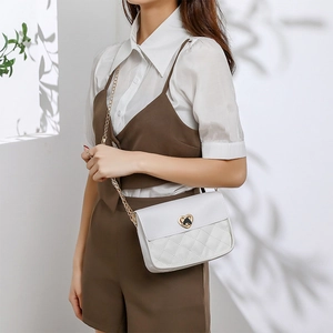 Elegant white quilted chain crossbody bag for women with gold heart-shaped buckle
